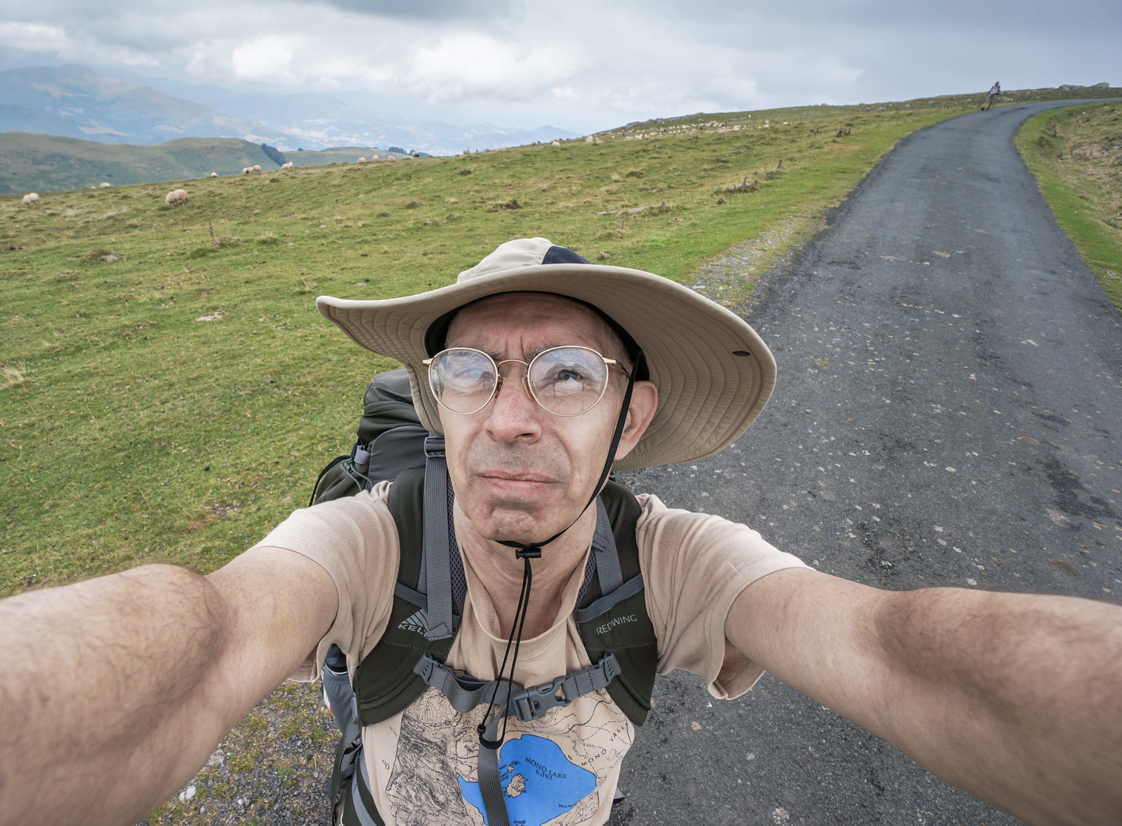 Self-portrait of pilgrim and photographer Mike Hudak on the Camino Frances with domesticated sheep in the Pyrenees 13.7 km from Saint-Jean-Pied-de-Port | Photo by Mike Hudak