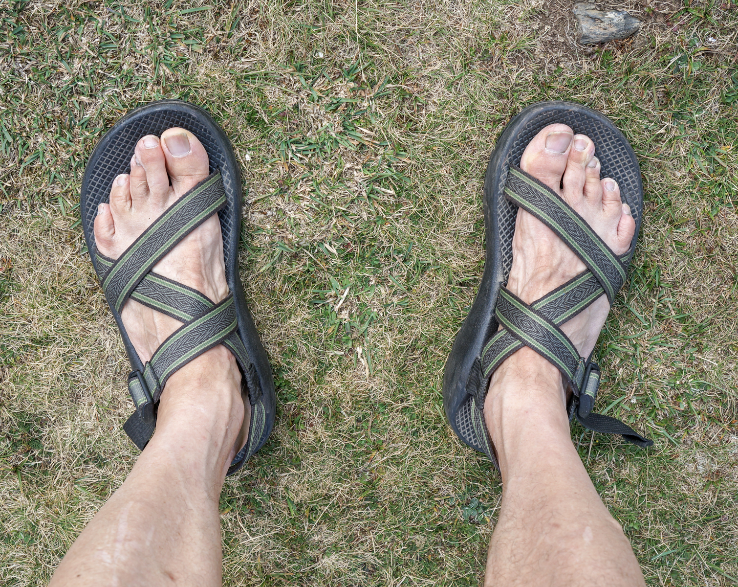 The photographer's bare feet in sandals on the first day of walking the Camino Frances in the French Pyrenees | Photo by Mike Hudak