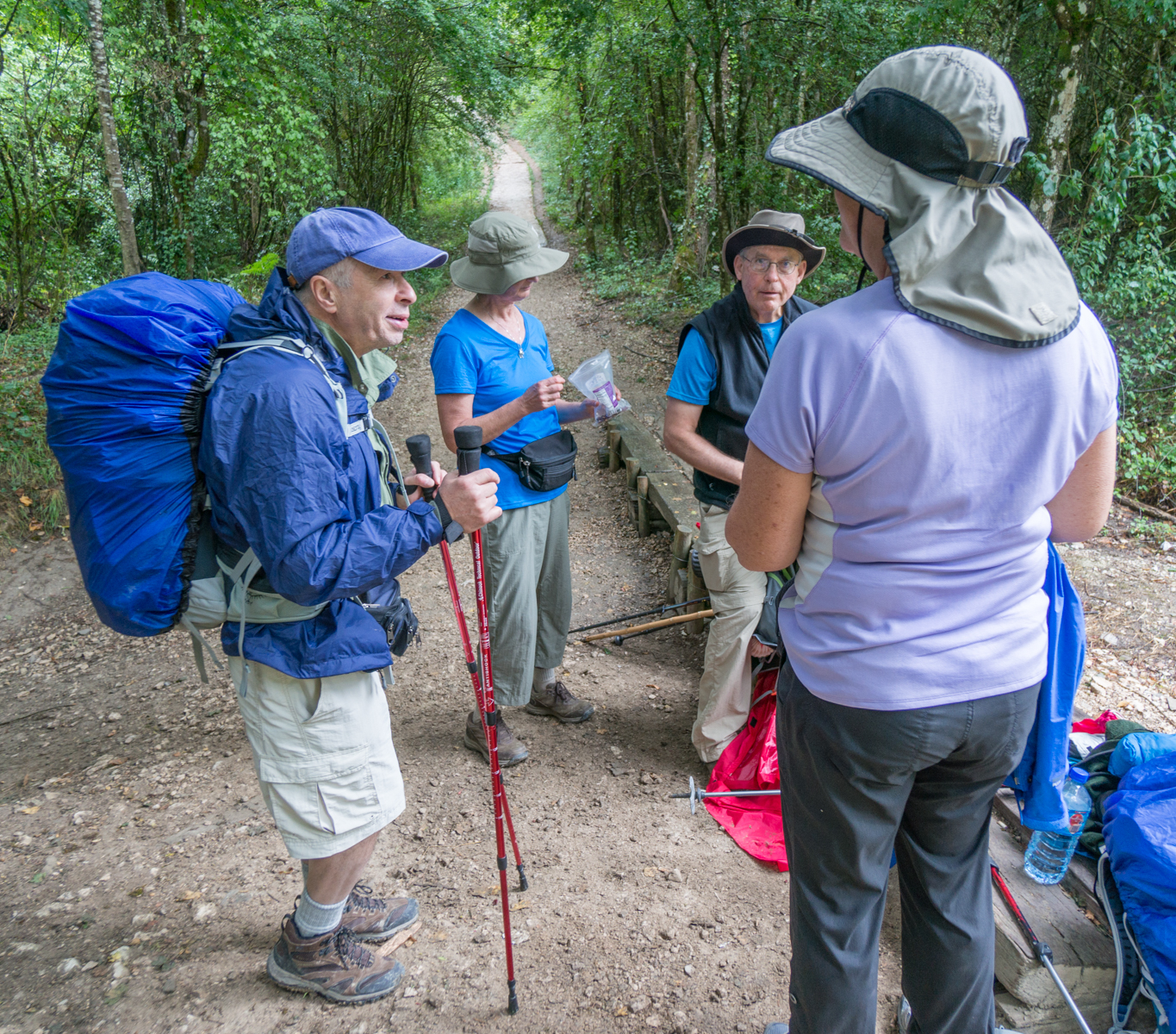 Camino pilgrims pause for a lunchtime snack in forest 3.2 km west of Zuriain, Spain | Photo by Mike Hudak.