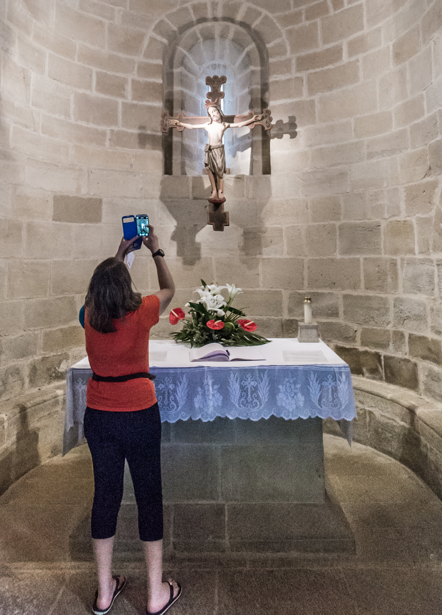 A Camino pilgrim photographs the 13th-century cruciix in the 12th-century Iglesia de Santo Sepulcro (Church of the Holy Sepulchre) in Torres del Rio, Spain | Photo by Mike Hudak