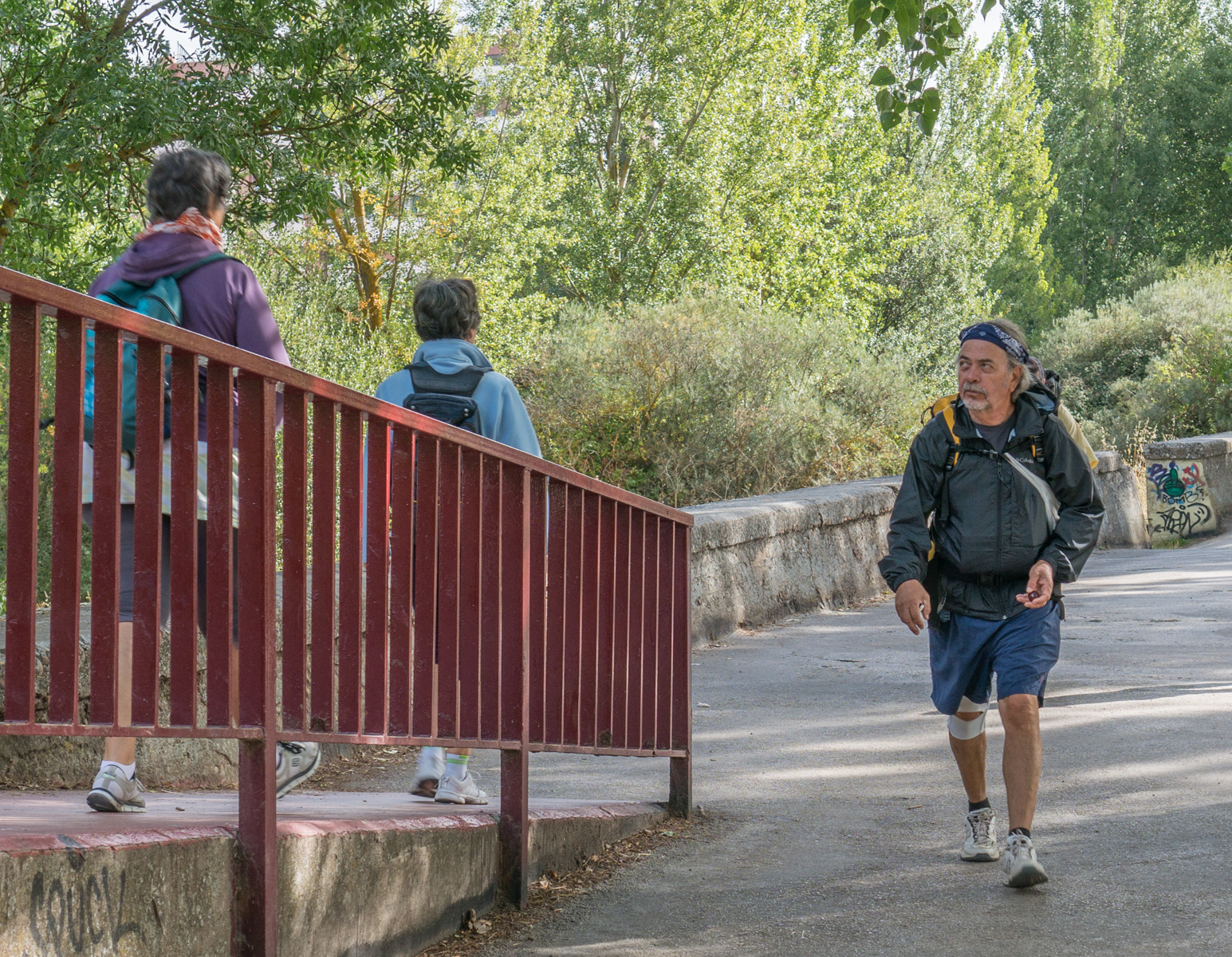 A male pilgrim on the Camino Francés where it’s conjoined with a pedestrian park path adjacent to the rio Arlanzón in Burgos, Spain | Photo by Mike Hudak
