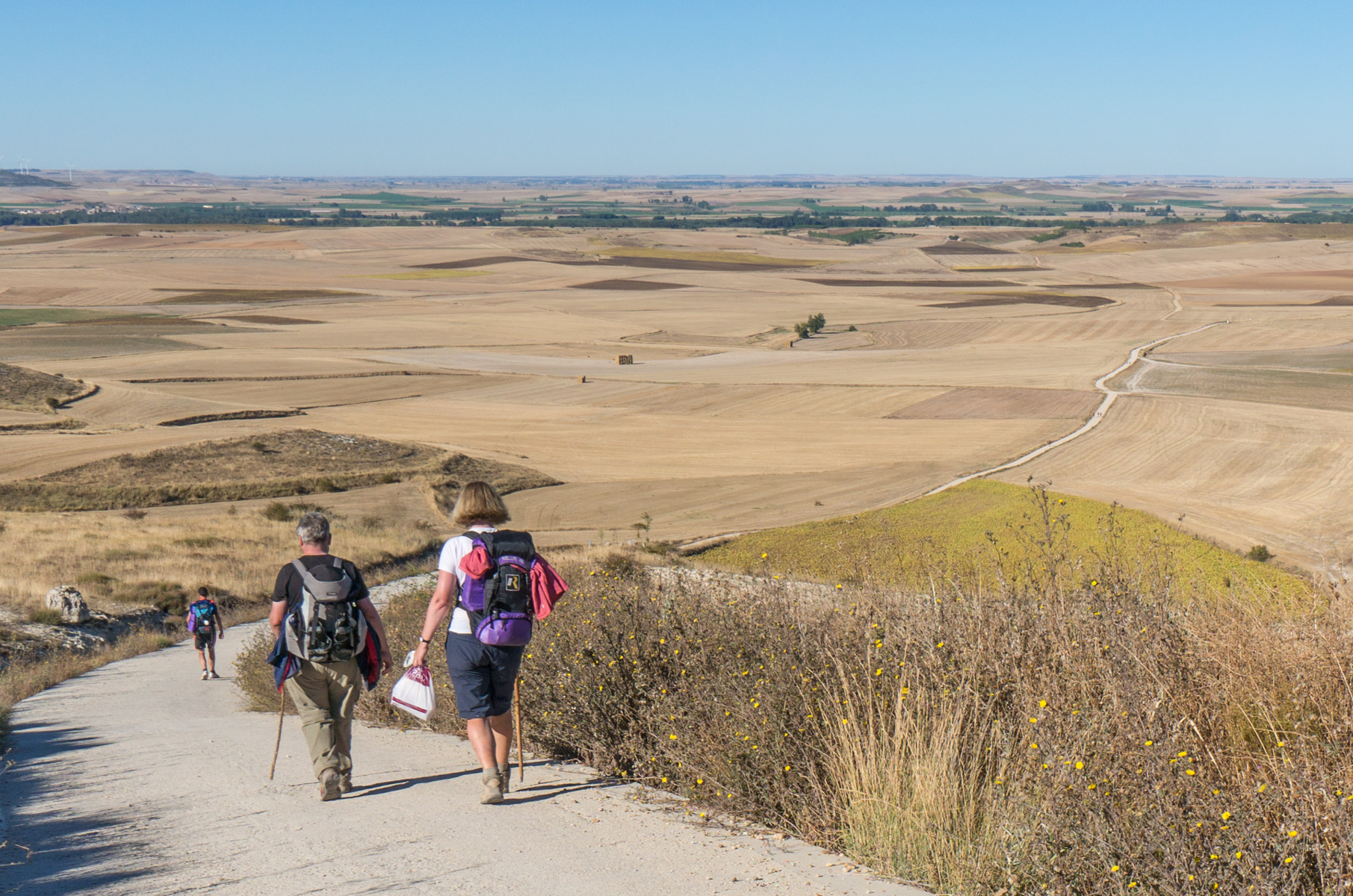 Camino pilgrims descend the western slope of Alto Mostelares (Spain) | Photo by Mike Hudak