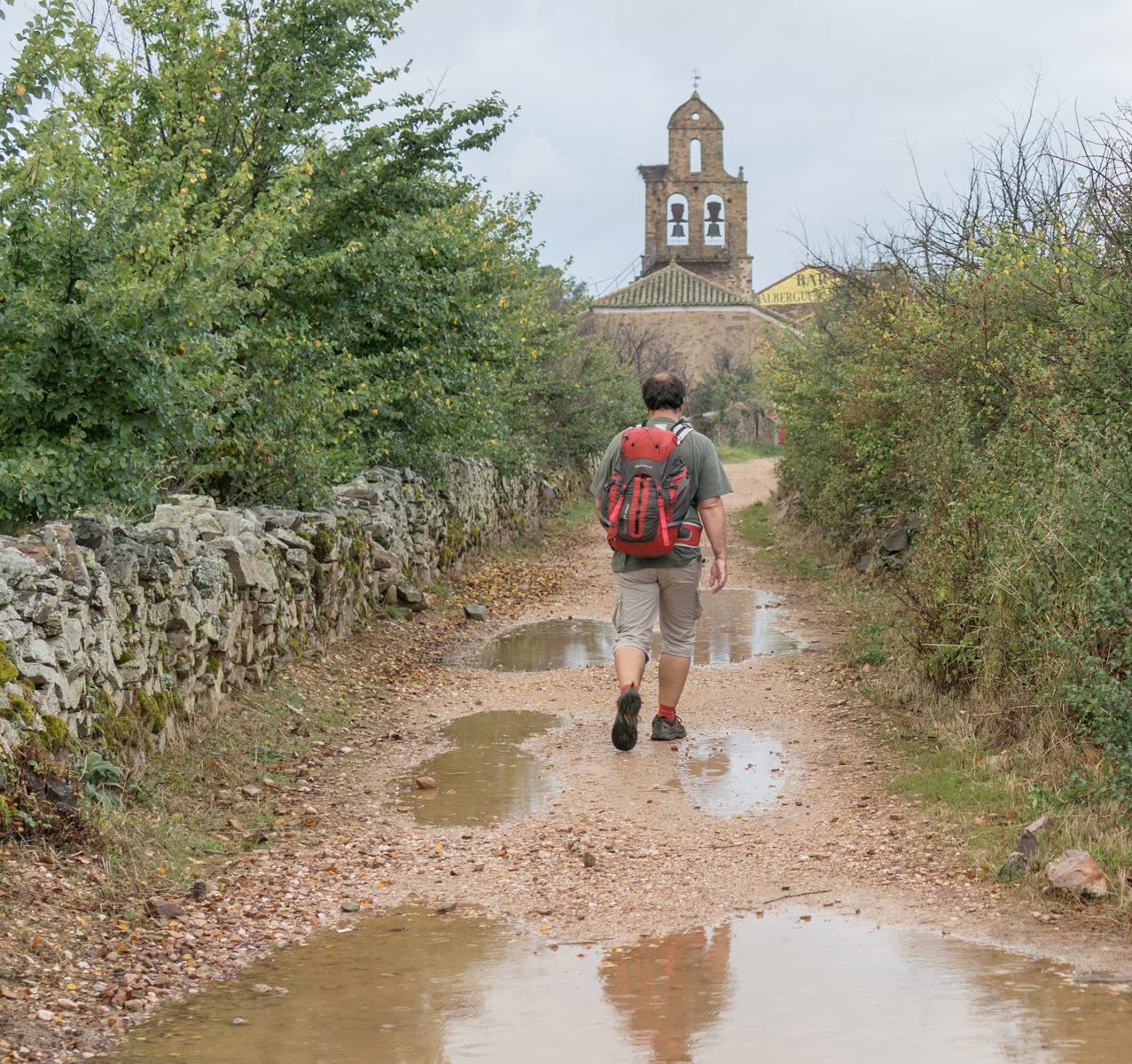 A pilgrim on the Camino Francés approaches the town of Santa Catalina de Somoza, Spain | Photo by Mike Hudak