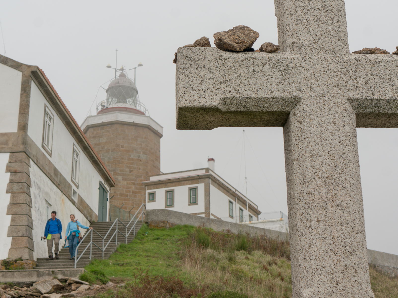 Finisterre Lighthouse and pilgrim memorial viewed from a slope steeply descending toward the Atlantic Ocean | Photo by Mike Hudak