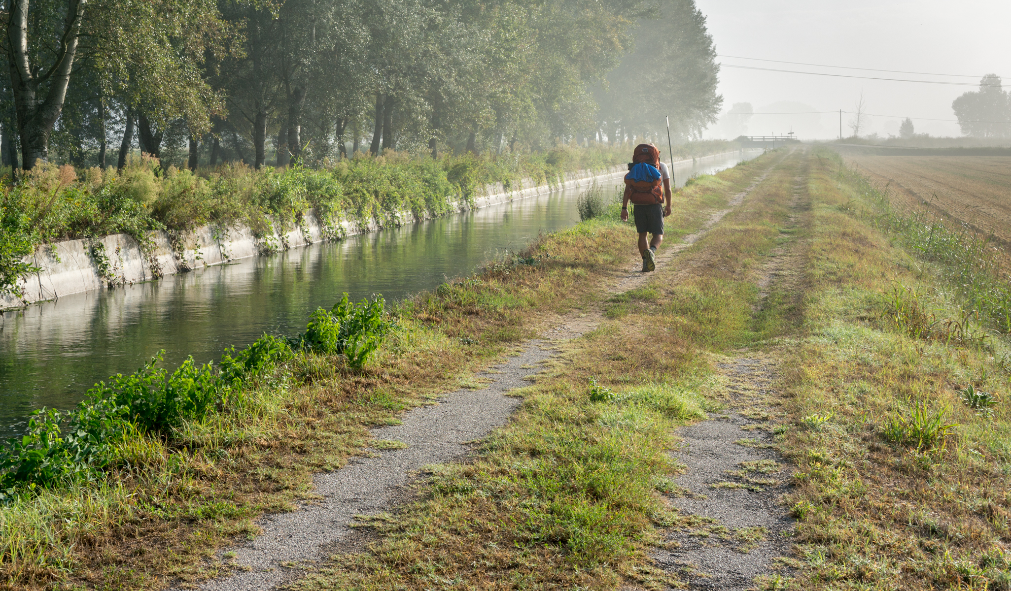 A pilgrim on the Via Francigena shortly beyond Gropello Cairoli, Italy | Photo by Mike Hudak